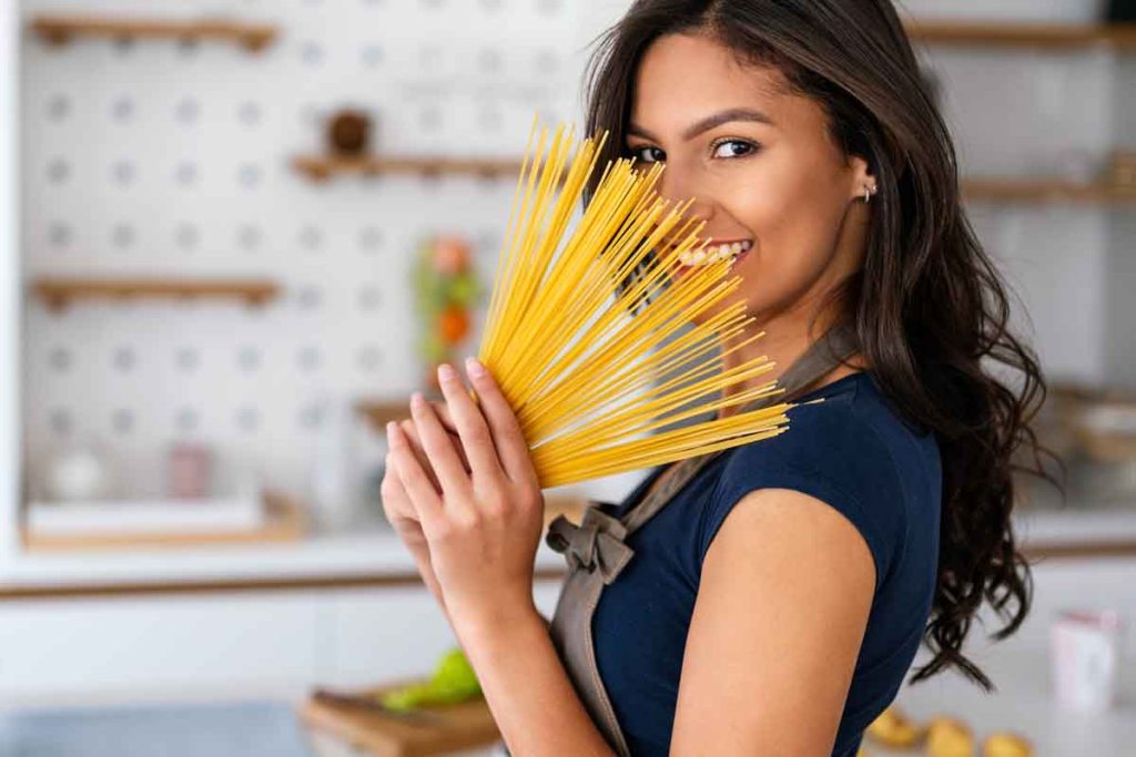 Beautiful young woman cooking in the kitchen. Healthy, organic, food people concept